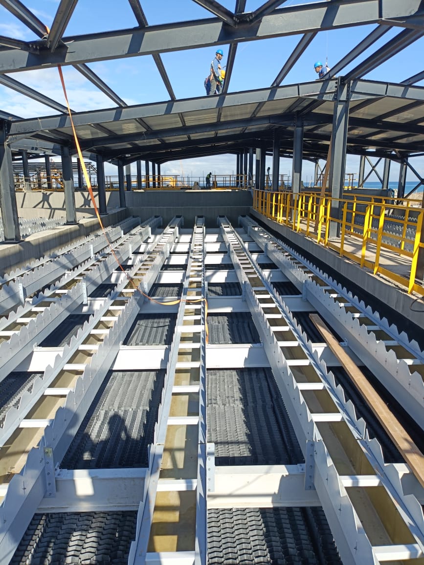 Montage de la charpente métallique et des grilles d'un bassin de filtration en bord de mer