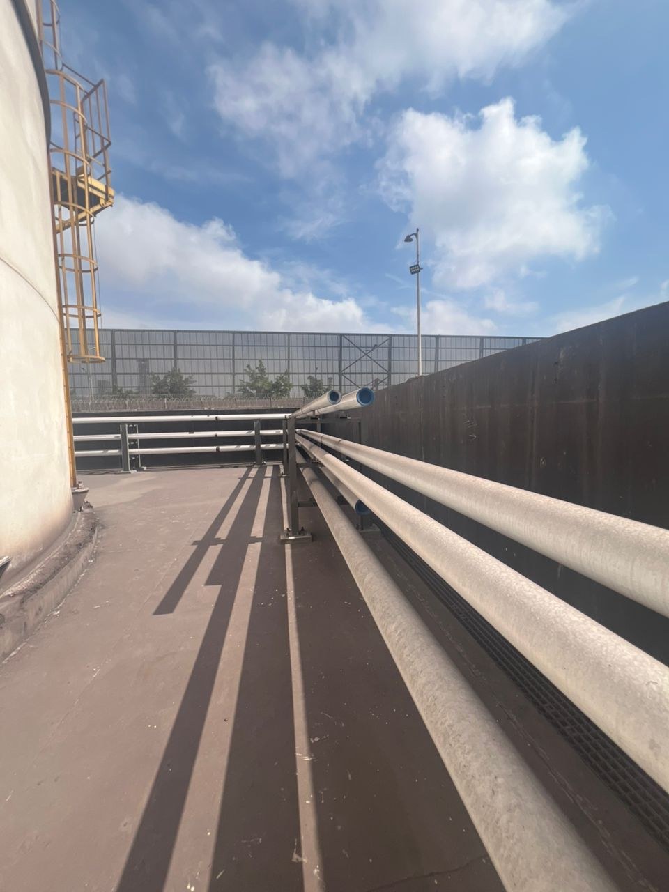 Lignes de tuyauterie le long d'un réservoir de stockage