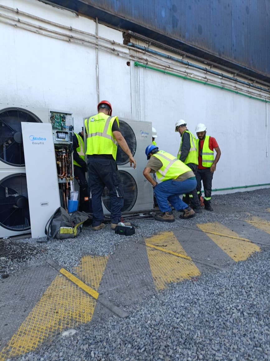Équipe technique en intervention de maintenance sur un groupe de climatisation